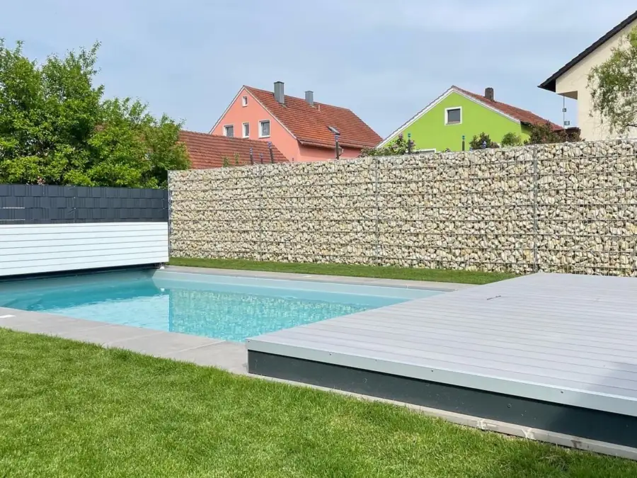 Klassisches Poolbecken mit Abdeckung und Gabionenwand